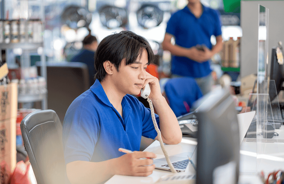 Service technician on phone in auto repair shop